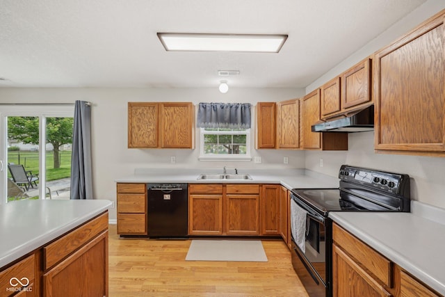 764 Port Dr, Avon, IN 46123 - kitchen with black appliances, under cabinet range hood, a sink, light wood-style floors, and plenty of natural light