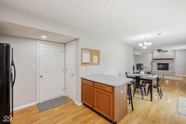764 Port Dr, Avon, IN 46123 - kitchen with freestanding refrigerator, light wood-style flooring, a chandelier, and brown cabinetry