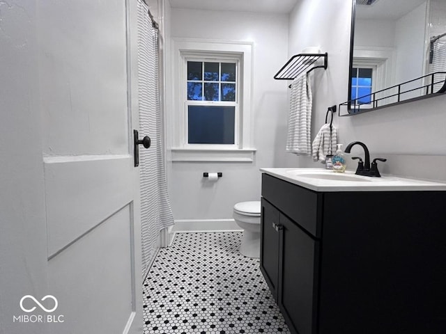 4040 Carrollton Ave, Indianapolis, IN 46205 - bathroom featuring toilet, vanity, and baseboards
