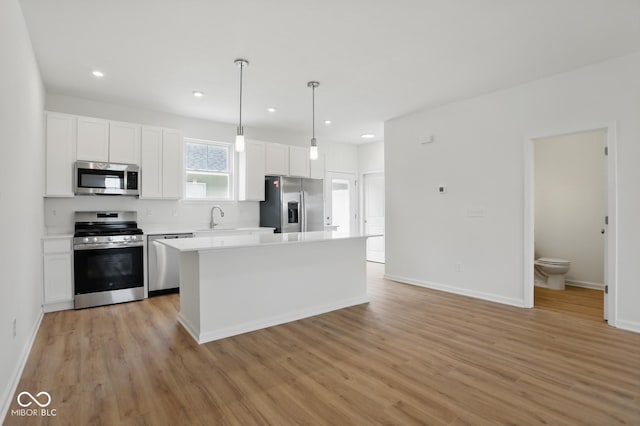 3947 Wren Dr, Brownsburg, IN 46112 - kitchen with appliances with stainless steel finishes, white cabinets, light countertops, light wood-type flooring, and baseboards