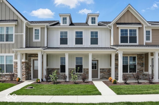 3947 Wren Dr, Brownsburg, IN 46112 - view of property with board and batten siding, stone siding, a porch, and a front lawn