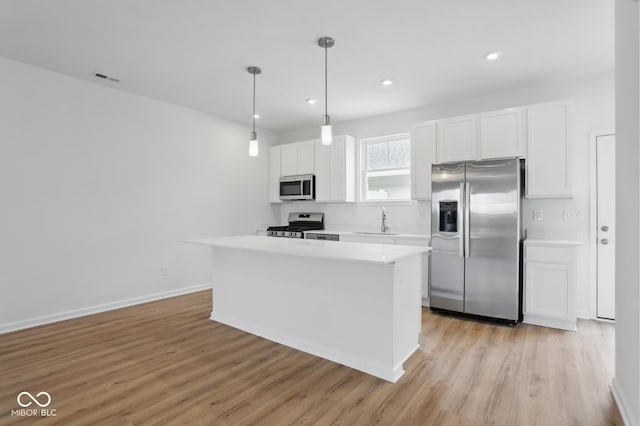3947 Wren Dr, Brownsburg, IN 46112 - kitchen with stainless steel appliances, a sink, white cabinets, light countertops, and light wood-type flooring