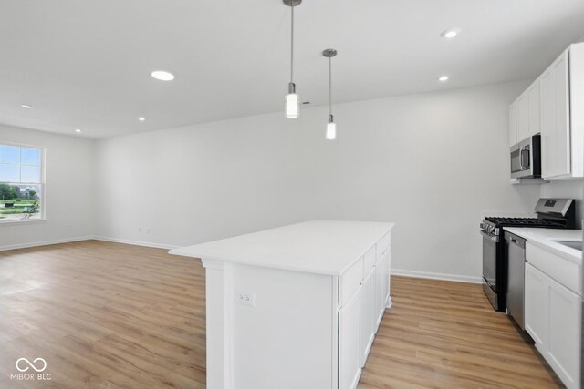 3947 Wren Dr, Brownsburg, IN 46112 - kitchen featuring stainless steel appliances, light wood-style flooring, light countertops, a kitchen island, and white cabinetry