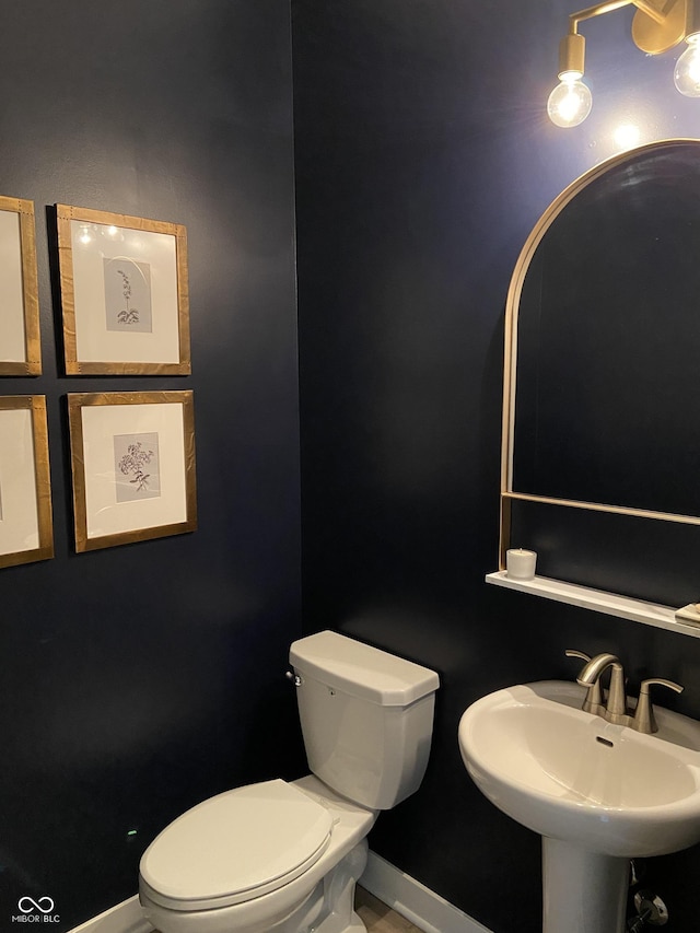 8876 Boylan Pl, Pendleton, IN 46064 - bathroom featuring toilet, baseboards, and a sink