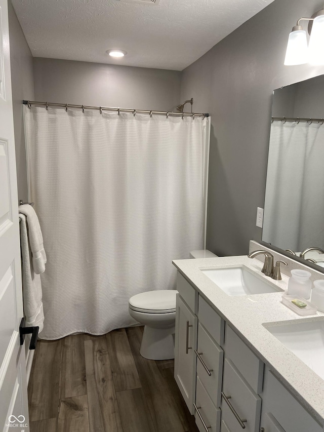 8876 Boylan Pl, Pendleton, IN 46064 - bathroom with wood finished floors, toilet, and double vanity