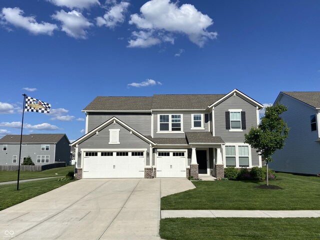 8876 Boylan Pl, Pendleton, IN 46064 - view of front of home featuring concrete driveway, a front lawn, brick siding, and an attached garage