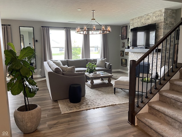 8876 Boylan Pl, Pendleton, IN 46064 - living area with stairway, baseboards, a chandelier, wood finished floors, and a textured ceiling