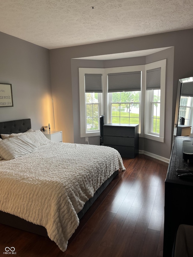 7601 Newport Bay Dr Unit 203, Indianapolis, IN 46240 - bedroom featuring dark wood finished floors, baseboards, and a textured ceiling