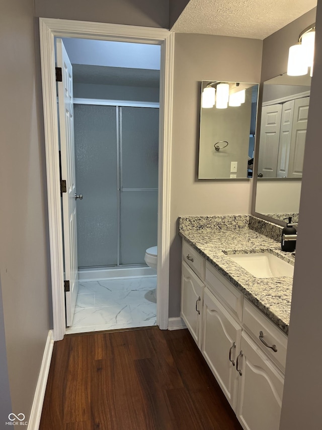 7601 Newport Bay Dr Unit 203, Indianapolis, IN 46240 - bathroom featuring toilet, vanity, a shower stall, marble look tiles, and baseboards