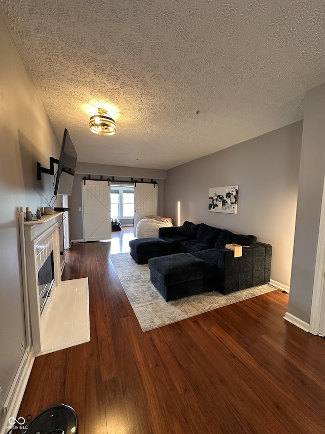 7601 Newport Bay Dr Unit 203, Indianapolis, IN 46240 - living room featuring a textured ceiling, dark wood-style flooring, baseboards, and a barn door