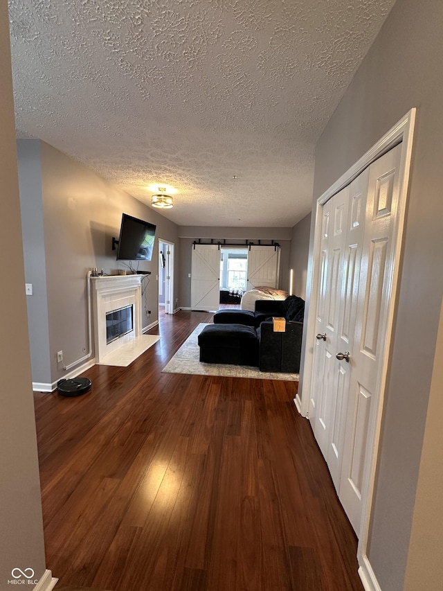 7601 Newport Bay Dr Unit 203, Indianapolis, IN 46240 - living area featuring a textured ceiling, dark wood-style floors, a tile fireplace, and baseboards