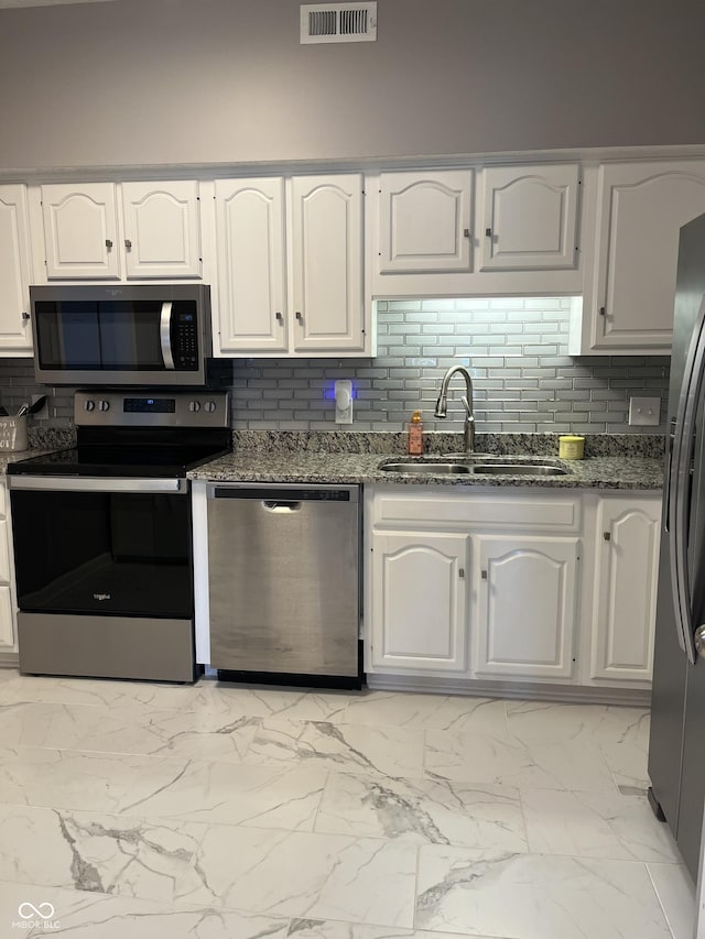 7601 Newport Bay Dr Unit 203, Indianapolis, IN 46240 - kitchen featuring stainless steel appliances, a sink, dark stone countertops, light marble finish flooring, and backsplash