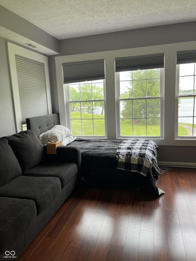 7601 Newport Bay Dr Unit 203, Indianapolis, IN 46240 - bedroom featuring a textured ceiling, dark wood finished floors, and a water view