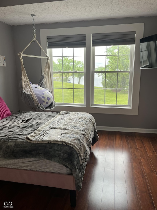 7601 Newport Bay Dr Unit 203, Indianapolis, IN 46240 - bedroom with hardwood / wood-style flooring, a water view, a textured ceiling, and baseboards