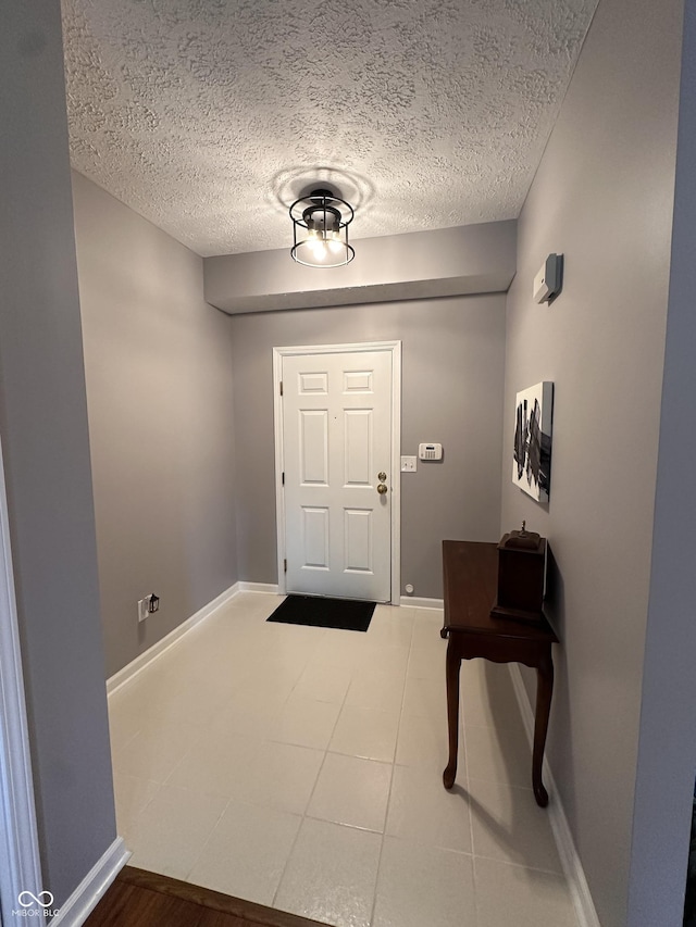 7601 Newport Bay Dr Unit 203, Indianapolis, IN 46240 - foyer featuring a textured ceiling, baseboards, and tile patterned floors