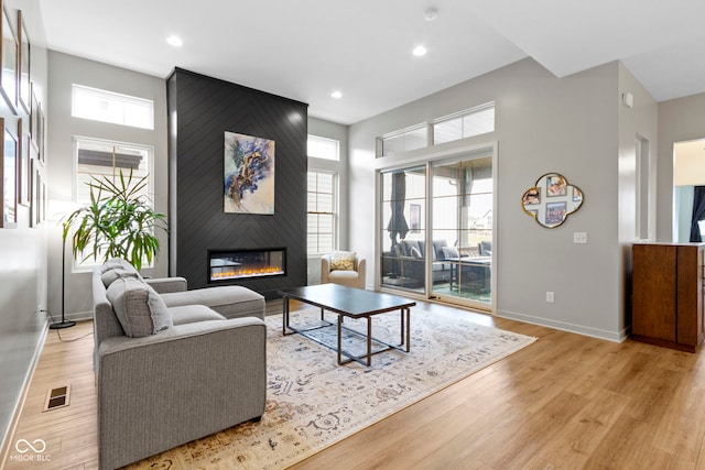 17359 Wilkes Way, Westfield, IN 46074 - living room featuring a large fireplace, plenty of natural light, light wood-style floors, recessed lighting, and a high ceiling