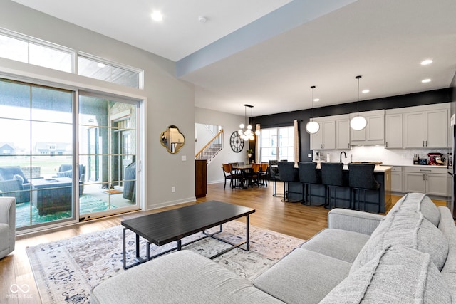 17359 Wilkes Way, Westfield, IN 46074 - living room featuring a chandelier, light wood finished floors, recessed lighting, stairway, and baseboards