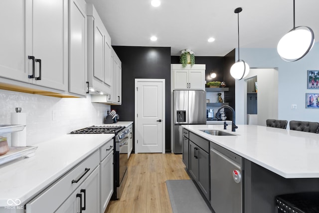 17359 Wilkes Way, Westfield, IN 46074 - kitchen featuring appliances with stainless steel finishes, a sink, backsplash, light countertops, and light wood finished floors