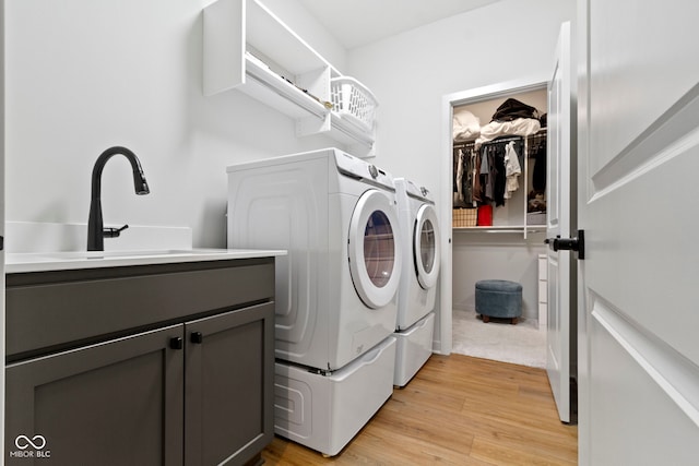 17359 Wilkes Way, Westfield, IN 46074 - laundry room with washer and clothes dryer, light wood-type flooring, and cabinet space