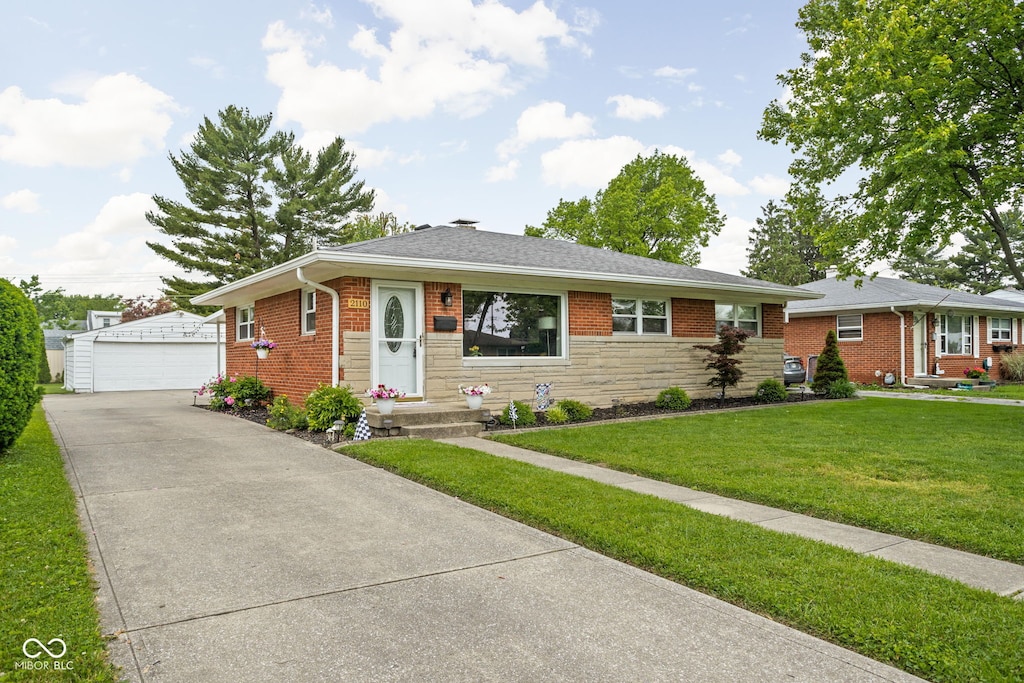 2110 Allison Ave, Speedway, IN 46224 - bungalow-style home featuring an outbuilding, a detached garage, a front lawn, brick siding, and stone siding