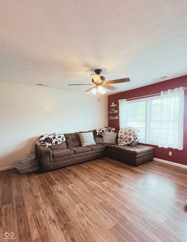 6460 W US Highway 50, North Vernon, IN 47265 - living room featuring a textured ceiling, wood finished floors, ceiling fan, and baseboards