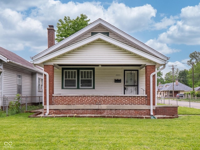 1065 36th St, Indianapolis, IN 46208 - shotgun-style home featuring covered porch, a chimney, and brick siding