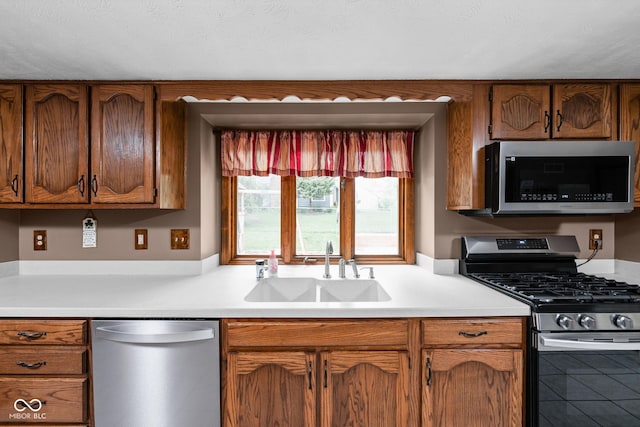 5412 Green Hills Dr, Brownsburg, IN 46112 - kitchen with stainless steel appliances, a sink, light countertops, and brown cabinets