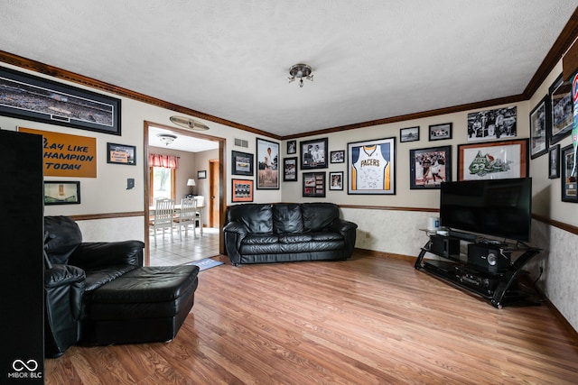 5412 Green Hills Dr, Brownsburg, IN 46112 - living area with wood finished floors, a textured ceiling, ornamental molding, and wainscoting