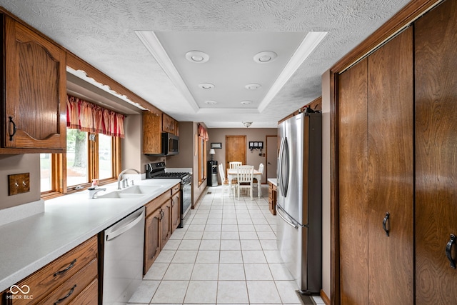 5412 Green Hills Dr, Brownsburg, IN 46112 - kitchen featuring appliances with stainless steel finishes, a sink, a raised ceiling, light tile patterned flooring, and light countertops