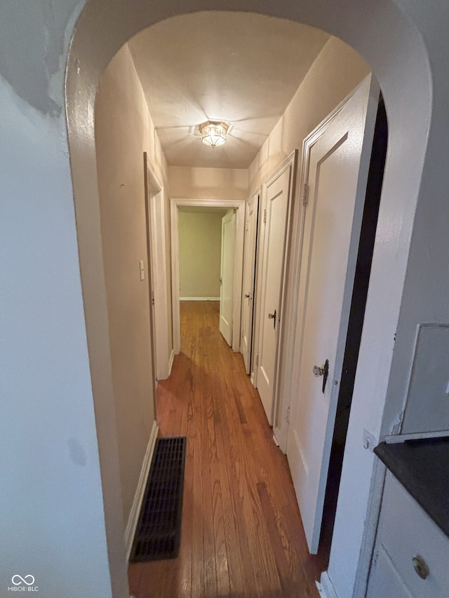 5472 E 10th St, Indianapolis, IN 46219 - hall featuring wood finished floors, arched walkways, and baseboards
