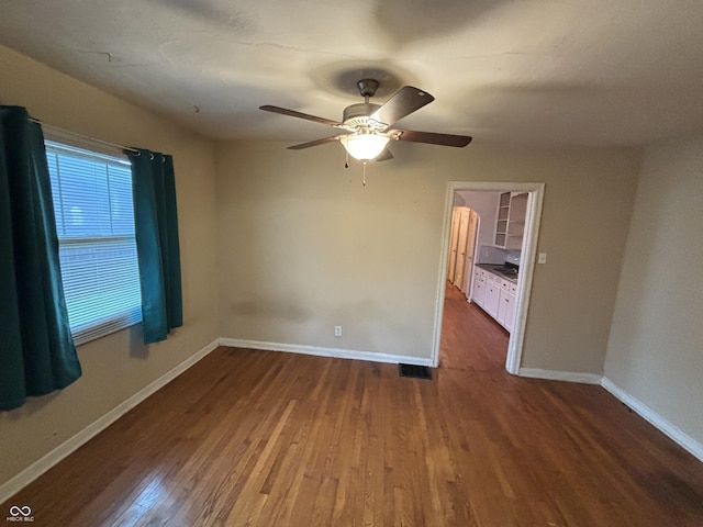 5472 E 10th St, Indianapolis, IN 46219 - empty room with wood finished floors, baseboards, and ceiling fan