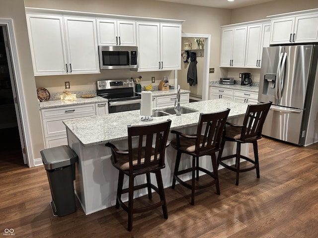 308 Bay Ridge Dr, Pendleton, IN 46064 - kitchen with appliances with stainless steel finishes, an island with sink, white cabinets, and dark wood-style floors