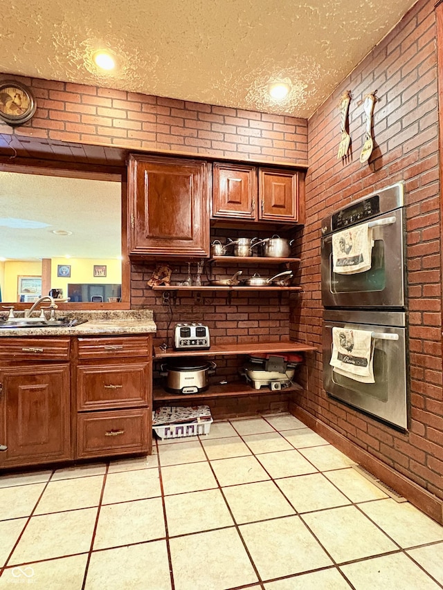 404 S Indiana St, Roachdale, IN 46172 - kitchen featuring stainless steel double oven, a textured ceiling, brick wall, light tile patterned floors, and open shelves