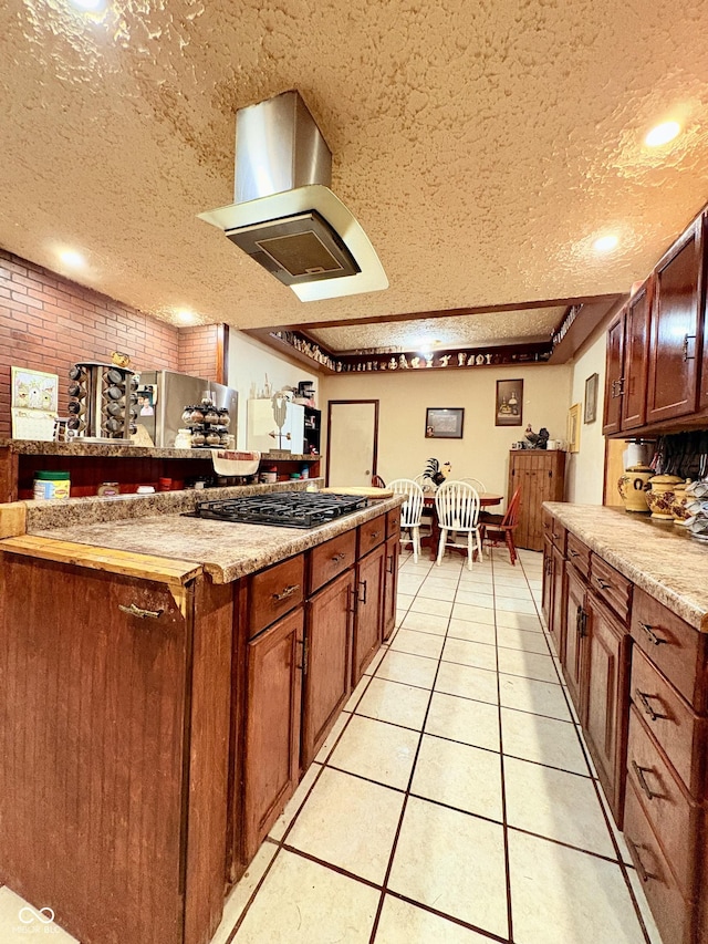 404 S Indiana St, Roachdale, IN 46172 - kitchen with wall chimney range hood, a textured ceiling, gas stovetop, light tile patterned flooring, and light countertops