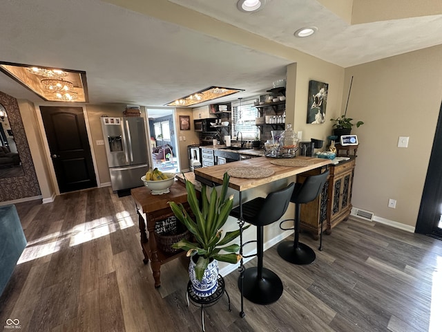 2028 Fairway Dr, Greencastle, IN 46135 - kitchen with stainless steel fridge, dark wood-type flooring, a peninsula, baseboards, and a chandelier