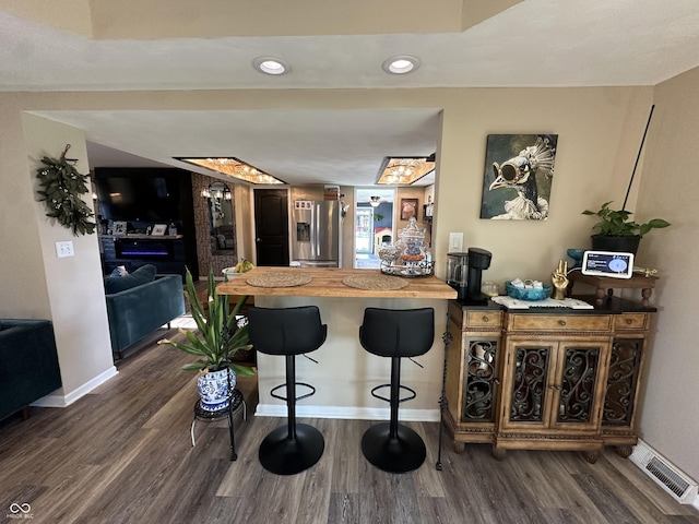 2028 Fairway Dr, Greencastle, IN 46135 - kitchen with stainless steel fridge, baseboards, dark wood-type flooring, a breakfast bar area, and recessed lighting