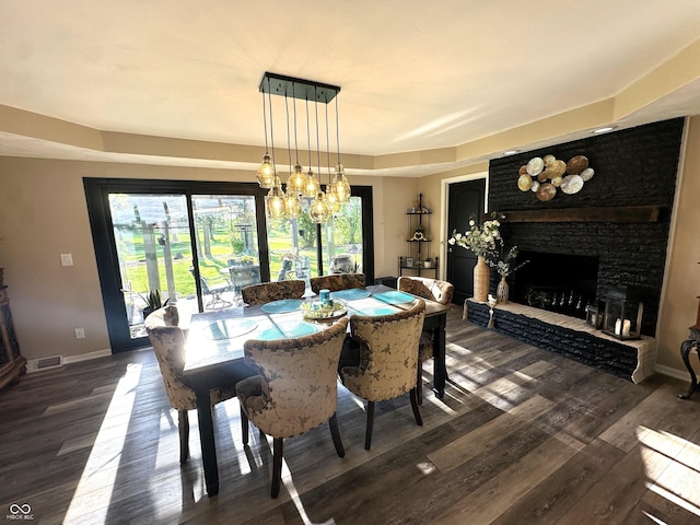 2028 Fairway Dr, Greencastle, IN 46135 - dining area featuring a fireplace, baseboards, dark wood-style flooring, and a chandelier