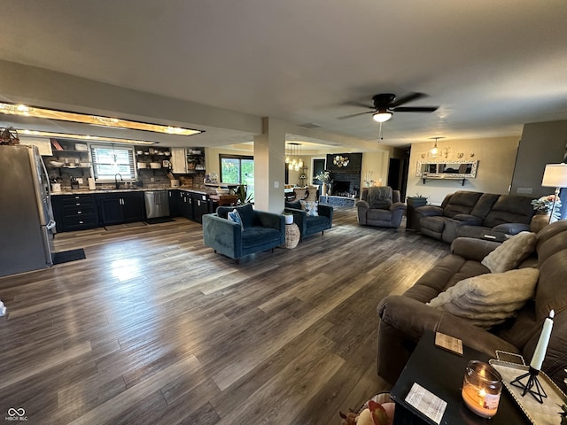 2028 Fairway Dr, Greencastle, IN 46135 - living area with a ceiling fan, dark wood finished floors, a chandelier, and a fireplace with raised hearth