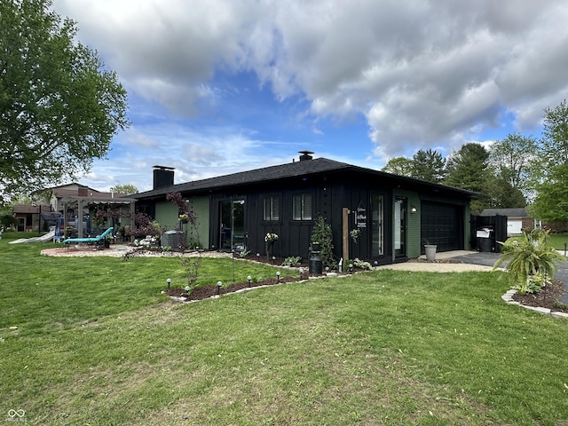 2028 Fairway Dr, Greencastle, IN 46135 - back of house with board and batten siding, an attached garage, driveway, a lawn, and a chimney