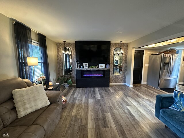 2028 Fairway Dr, Greencastle, IN 46135 - living room featuring a chandelier, dark wood-style floors, a glass covered fireplace, and baseboards