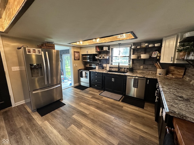 2028 Fairway Dr, Greencastle, IN 46135 - kitchen featuring appliances with stainless steel finishes, open shelves, a sink, wood finished floors, and backsplash