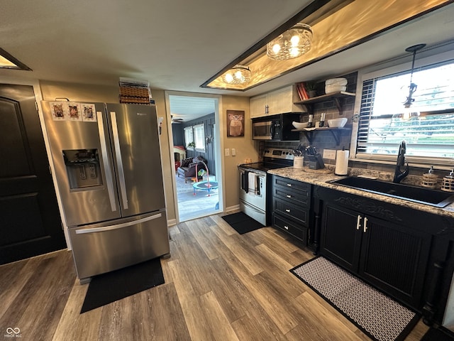 2028 Fairway Dr, Greencastle, IN 46135 - kitchen with stainless steel appliances, a sink, dark cabinets, wood finished floors, and baseboards