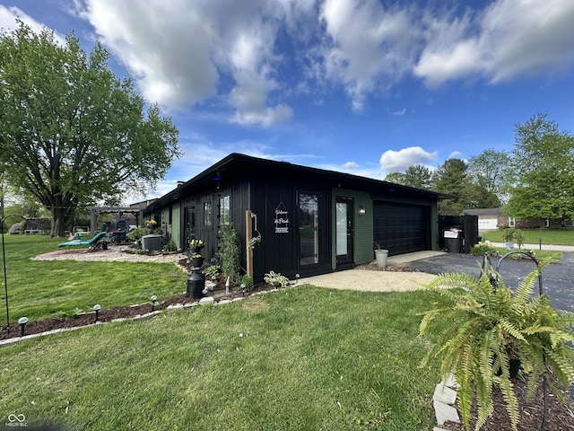 2028 Fairway Dr, Greencastle, IN 46135 - view of front of home featuring an attached garage, asphalt driveway, board and batten siding, a front yard, and cooling unit