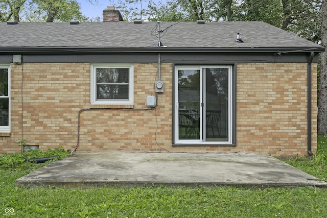 3526 Westfield Dr, Anderson, IN 46011 - rear view of house featuring brick siding, a patio, roof with shingles, and a chimney