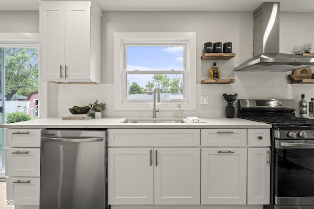 3526 Westfield Dr, Anderson, IN 46011 - kitchen featuring appliances with stainless steel finishes, wall chimney exhaust hood, a sink, white cabinets, and backsplash