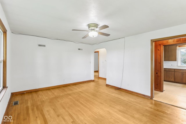 6012 S 625 W, Pendleton, IN 46064 - unfurnished room with light wood-type flooring, arched walkways, ceiling fan, and baseboards