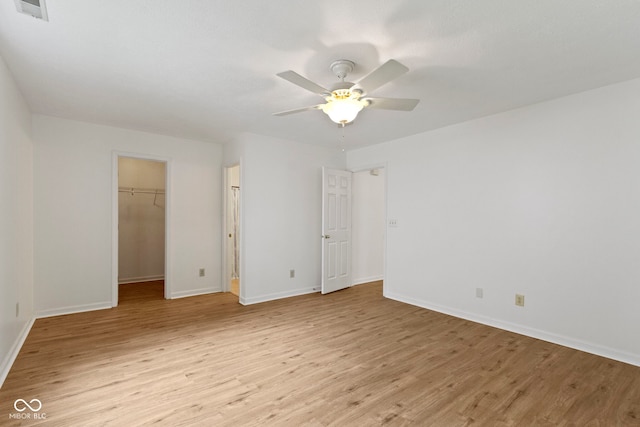 975 Atir Ln, Greenfield, IN 46140 - unfurnished bedroom with light wood finished floors, baseboards, a spacious closet, and a ceiling fan