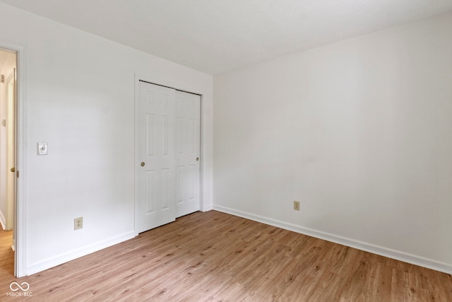 975 Atir Ln, Greenfield, IN 46140 - unfurnished bedroom featuring light wood-type flooring, baseboards, and a closet