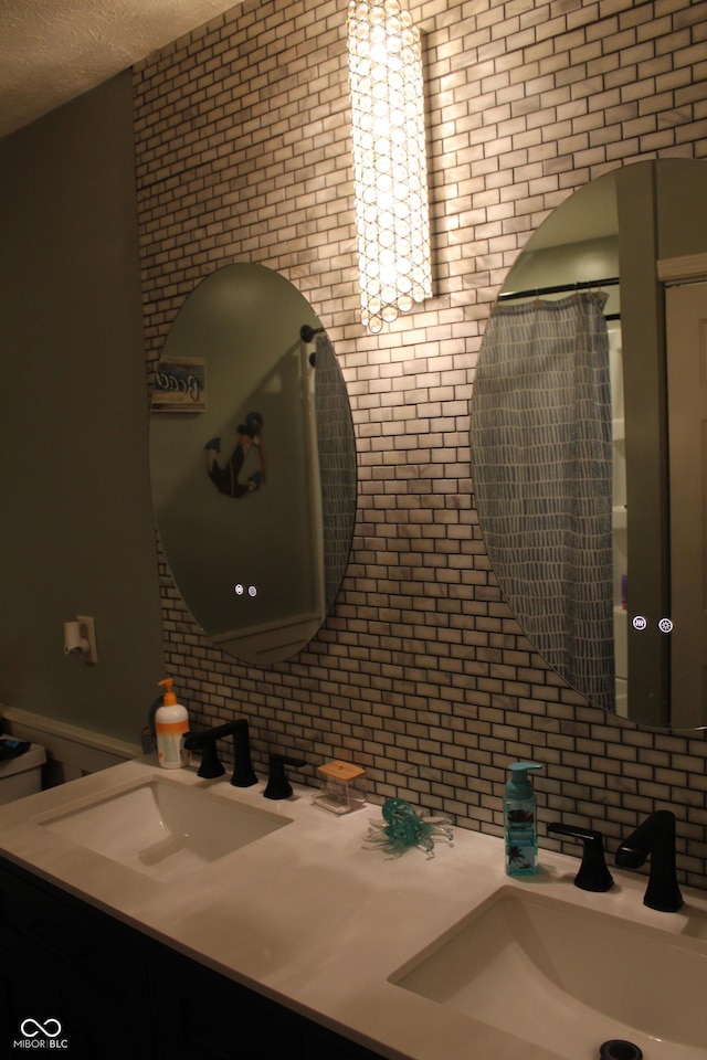 5101 W Bay Rd, Plainfield, IN 46168 - full bath featuring double vanity, brick wall, and a textured ceiling