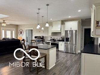 217 N Liberty Blvd, Mooresville, IN 46158 - kitchen with stainless steel appliances, premium range hood, a sink, dark countertops, and ceiling fan